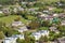 panoramic aerial view of small provincial town or big eco village with wooden houses, gravel road, gardens and orchards