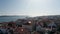 Panoramic aerial view of town with long cable-stayed bridge spanning Tagus river. Drone camera descending between