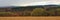 Panoramic Ardennes landscape,with empty winter farmland and forests and hills on a rainy day with dark clouds