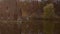 Panoramic b-roll of autumn scenic landscape. Wooden house by lake among forest, pretty girl walking by wooden pier