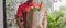 Panoramic banner. delivery man in red uniform holding fresh food set bag waiting for customer at door home, food delivery service,