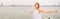 Panoramic banner image of Portrait of a beautiful woman in white dress with free carefree happy girl looking at ocean with open