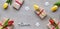 Panoramic banner Spring flat lay, light grey stone background. Gifts wrapped in craft paper, word love. Yellow, magenta