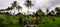 Panoramic beautiful and green balinese style garden with the ocean on the horizon on a cloudy day