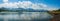 Panoramic beauty: dam, mountains, and clear blue sky create a stunning vista