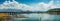 Panoramic beauty: dam, mountains, and clear blue sky create a stunning vista