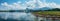 Panoramic beauty: dam, mountains, and clear blue sky create a stunning vista