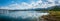 Panoramic beauty: dam, mountains, and clear blue sky create a stunning vista