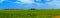 Panoramic countryside wide view with trees behind. Rural summer