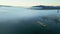 Panoramic drone view of a barge floating in dense fog on the Rhone River in the morning. In the town of Le Pouzin