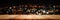 Panoramic empty clean wood counter table top on blur street night cafe background use for pub coffee shop montage dark scene,