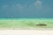Panoramic endless view over white sand on turquoise green water with wooden traditional dau sailing boats - Paje beach, Zanzibar