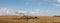 Panoramic of a fallen dried dead native tree left to become native animal habitat by the edge of a farm field in rural Victoria,