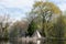 Panoramic horizontal spring view of a tipi with its reflection in a pond, Montreal Botanical Garden
