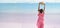 panoramic image rear view of woman standing at desert horizon of pink lake salt flats