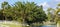 Panoramic image of rural pastures with white fences on a canal on a sunny day.