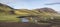 Panoramic landscape with colorful tents at camping site on blue Alftavatn lake with green hills and glacier in beautiful