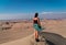 Panoramic landscape from a desert an a woman standing alone over a dune. Ica, Peru