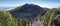 Panoramic landscape with lush green pine trees, colorful volcanoes and lava crater Deseada along path Ruta de los