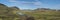 Panoramic landscape with mountain huts at camping site on blue Alftavatn lake with river, green hills and glacier in