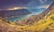 Panoramic landscape of mountain ridge with path descends down and Kotor bay at distance.