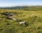 Panoramic landscape view across Dartmoor National Park in Summer with wide views of several tors and valleys