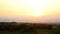 Panoramic landscape view of many modern wind turbine farm power generation station against warm sunset haze mist sky