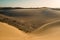 Panoramic landscape view of maspalomas sand desert dunes with the city and mountains in background on a sunny summer day