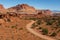 A panoramic landscape view of the red, rugged and barren Canyonlands National Park, Utah with a dirt road weaving its way through
