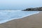 Panoramic landscape view of silky and foamy sea waves of Arabian Sea, swashing on rocky and sandy Gokarna Main Beach or Gokarna