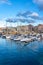 Panoramic marina with many small sailing boats docked on the shore of the city of Gijon, Asturias, Spain.