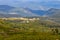 Panoramic mountains view with village and shadow of clouds on green forest valley. Carpathian mountains in perspective.