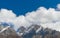 Panoramic movement of fuzzy floating Clouds flowing over Mountain summit in Blue sky backdrop. Nature background. Copy space room