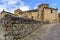 Panoramic of old stone Romanesque church with cobblestone pavement and blue, sky. Santillana del Mar