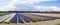 A panoramic photo of long bulb fields with hyacinths in various colors with a strip of contrasting yellow tulips in the back combi