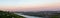 Panoramic photo of Ufa skyline in city center with buildings, river, forest area on beautiful pink-blue sunset.