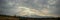 Panoramic picture of dramatic looking sky sunrise with sunrays or angel rays with Rocky Mountains along the Wasatch Front, and Sal