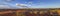 Panoramic picture over the Namibian Kalahari in the evening at sunset with blue sky and light clouds