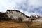 The panoramic of the Potala Palace, with the people republic of China flag inside as well as Potala Palace square, trees and meado