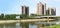 Panoramic reflection of riverbank trees, buildings and bridges