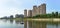 Panoramic reflection of riverbank trees, buildings and bridges