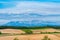 Panoramic rural landscape with mountains. Vast blue sky and white clouds over farmland field