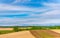 Panoramic rural landscape with mountains. Vast blue sky and white clouds over farmland field