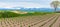 Panoramic rural landscape with mountains. Vast blue sky and white clouds over farmland field