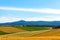 Panoramic rural landscape with mountains. Vast blue sky and white clouds over farmland field in a beautiful sunny day