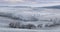 Panoramic Rural Landscape With Wavy Plowed Fields, Trees In Hoarfrost And Old Windmill In Morning Fog. Winter Arable Land. Beautif