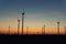 Panoramic scenic landscape view new modern wind turbine farm power generation station against fiery warm sunset sky