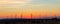 Panoramic scenic landscape view new modern wind turbine farm power generation station against fiery warm sunset sky