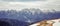 Panoramic scenic view from Baiului Mountains with the snowy peaks of Bucegi Mountains.