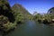 Panoramic scenic view of Nam Song Xong river amidst trees and rural karst hills landscape against blue clear sky , near Vang